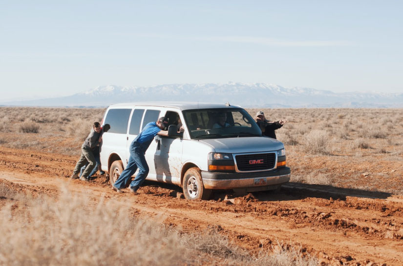 People pushing a vehicle